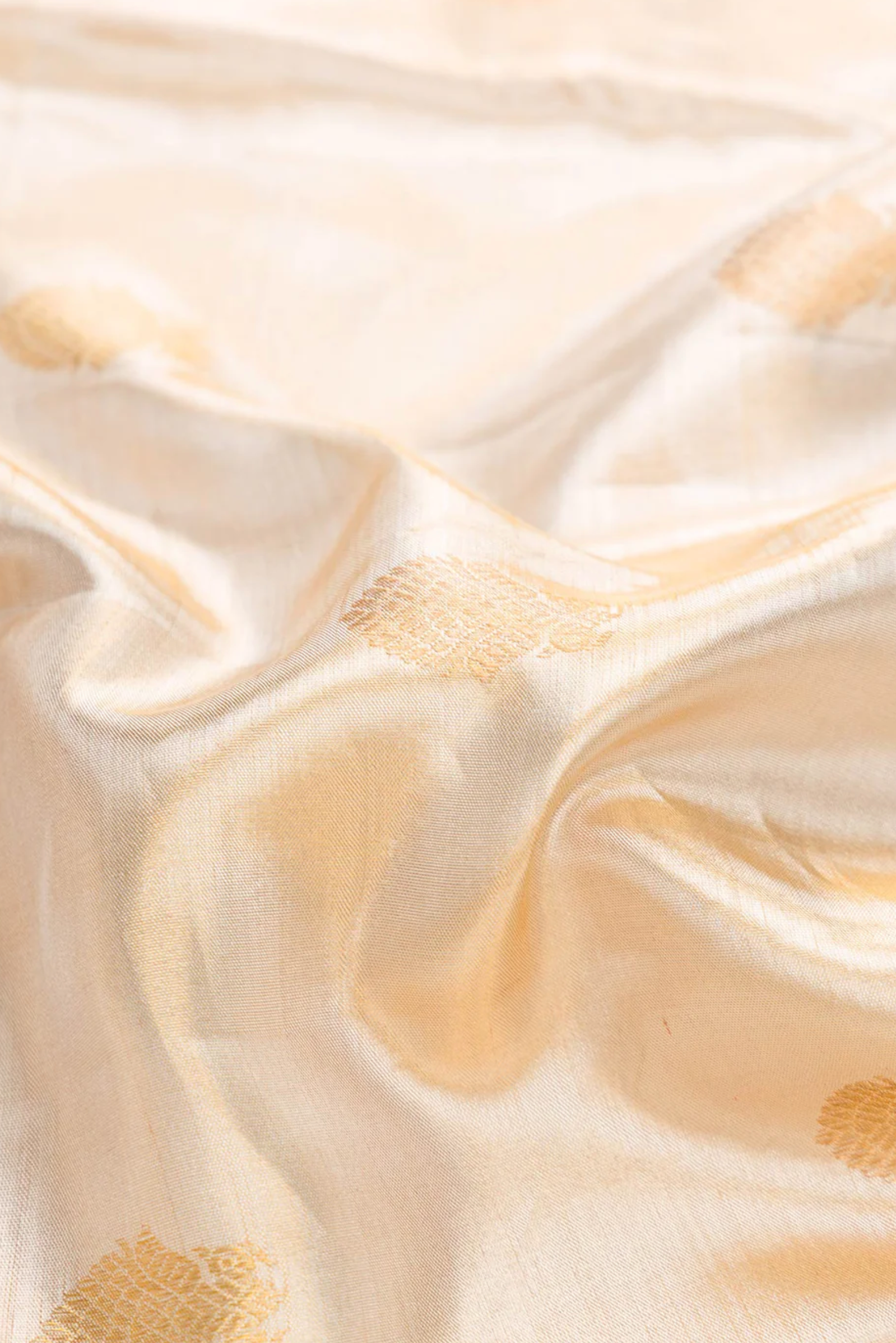 Close-up of beige fabric with gold accents